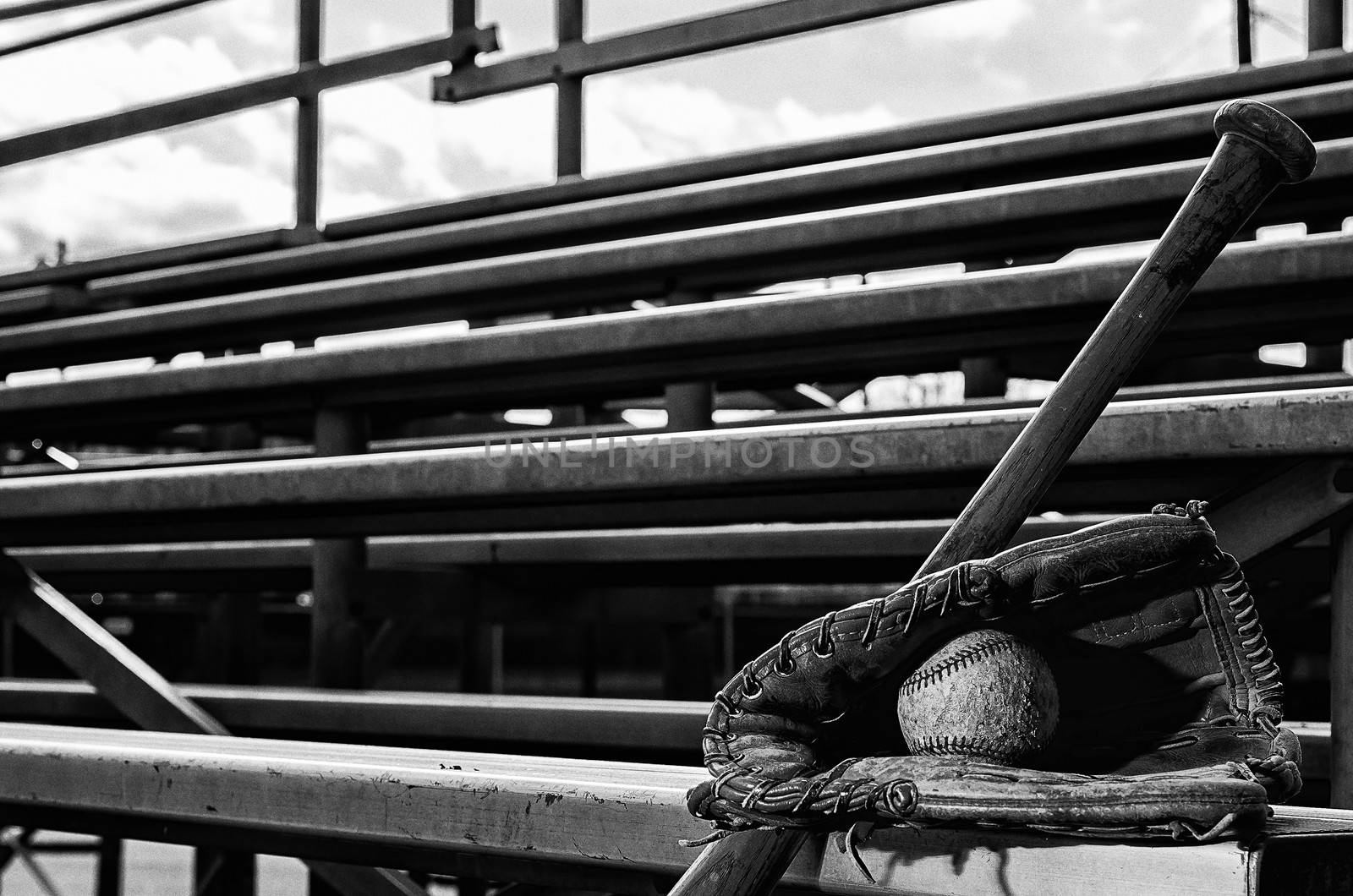 Baseball practice monochrome with ball in glove and bat on bleachers.