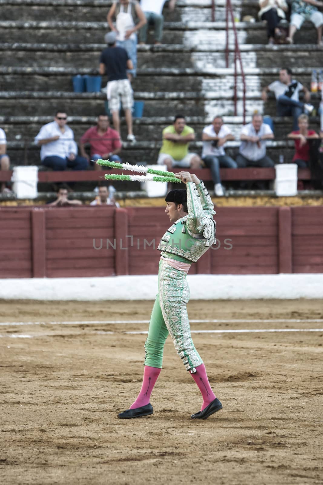 Andujar, Jaen province, SPAIN - 10 september 2011: Spainish bullfighter with the whitw and green flags high to attract the bull in the Bullring of Andujar, Jaen province, Andalusia, Spain