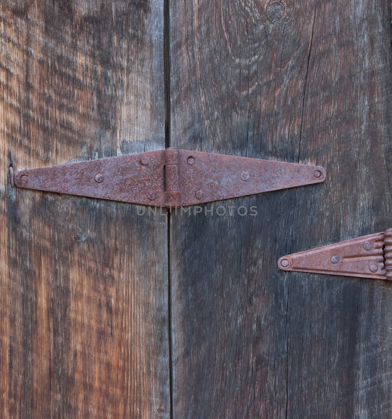 Background and texture photo of an old rusty hinge on an old ghost town door.