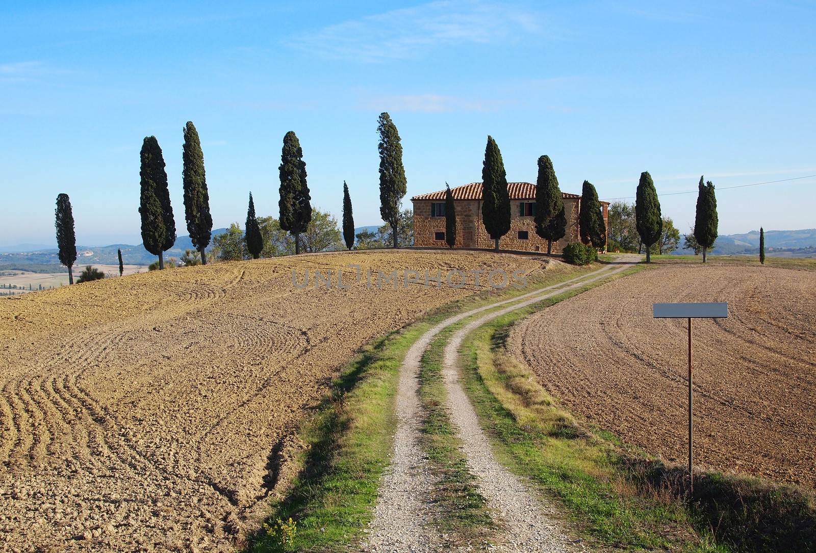 Typical house with cypress trees near Pienza in the Orcia Valley in Tuscany, Italy.