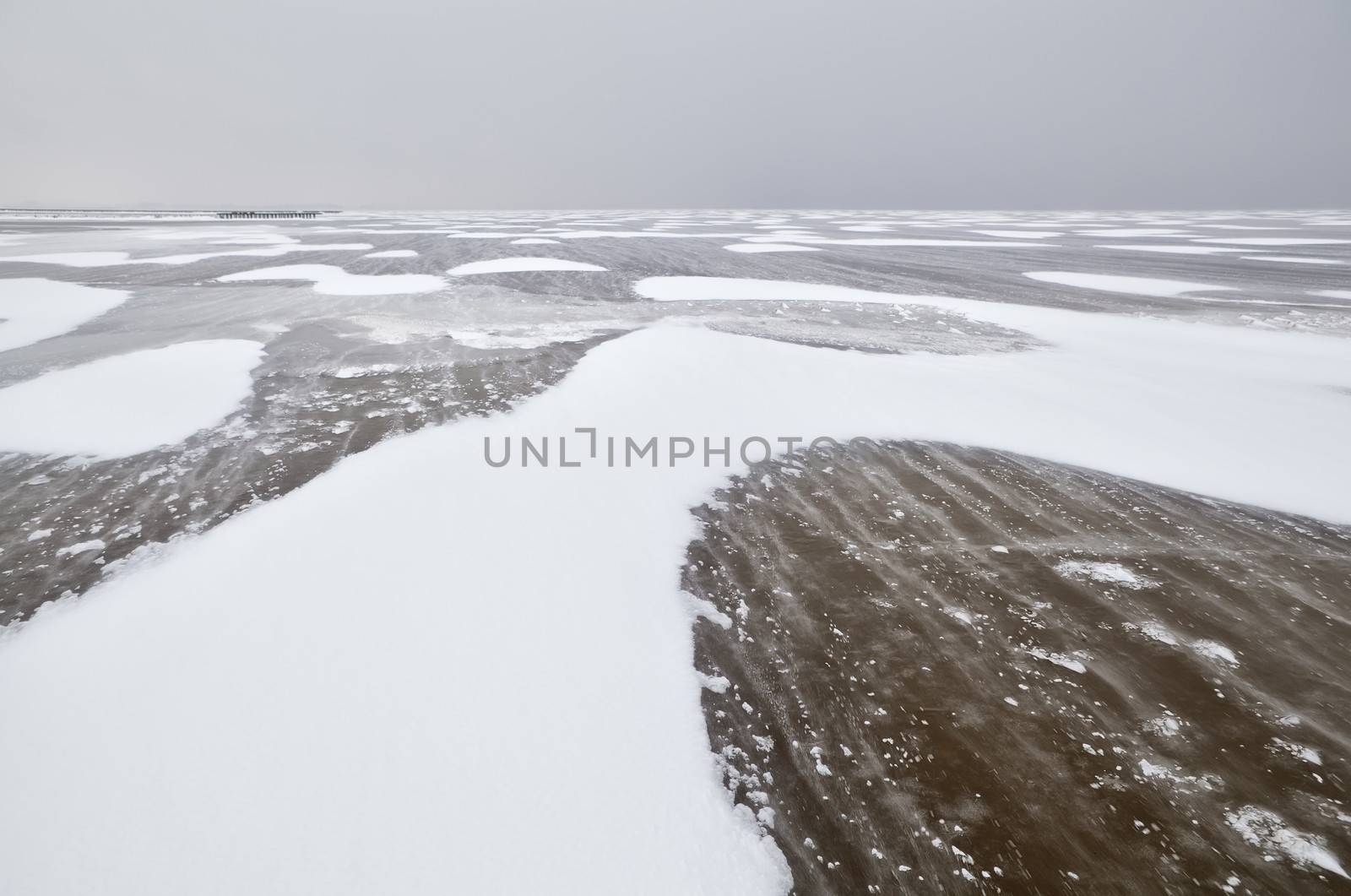 wind create snow texture on frozen lake by catolla