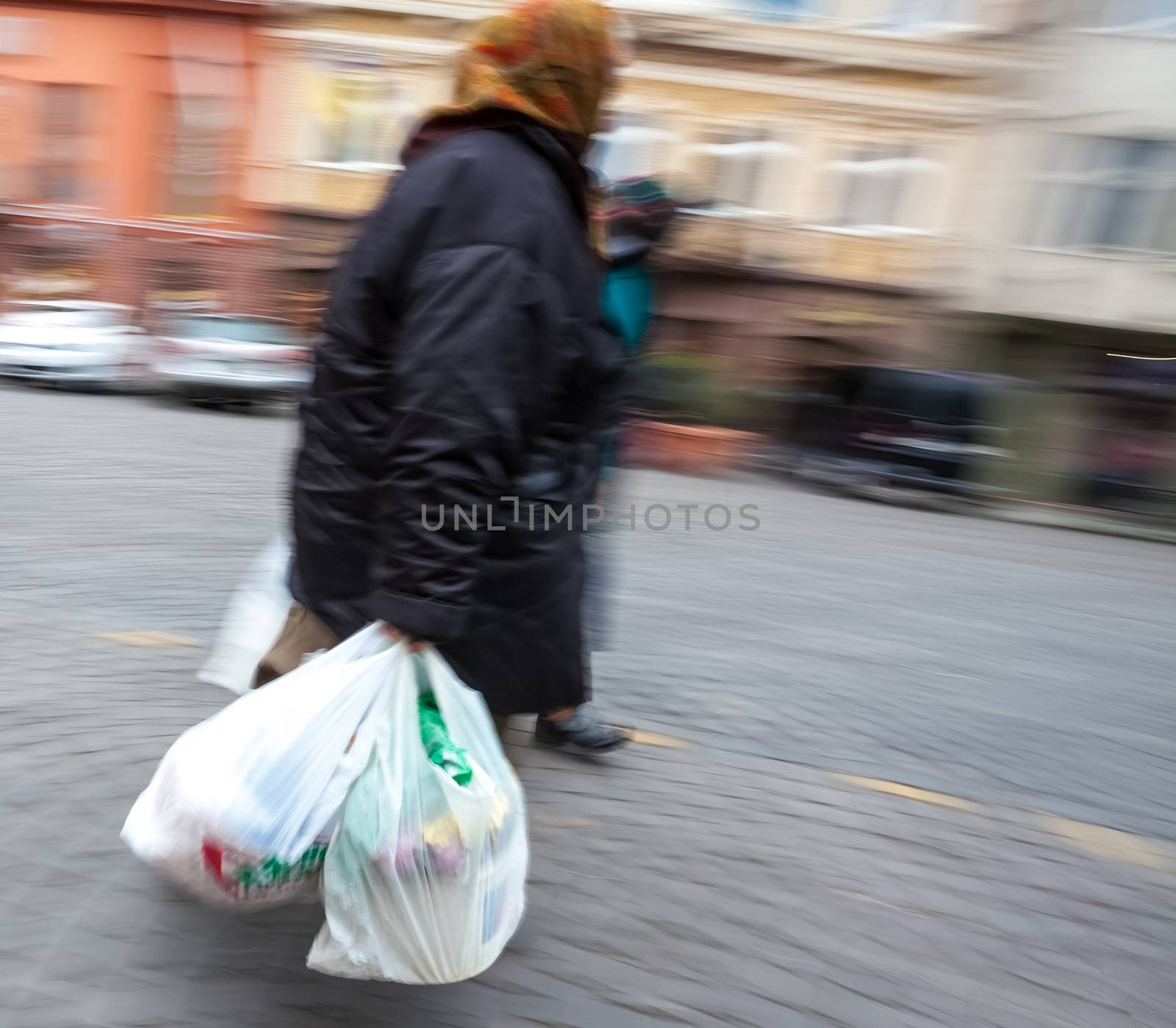Old woman with plastic bags. Intentional motion blur
