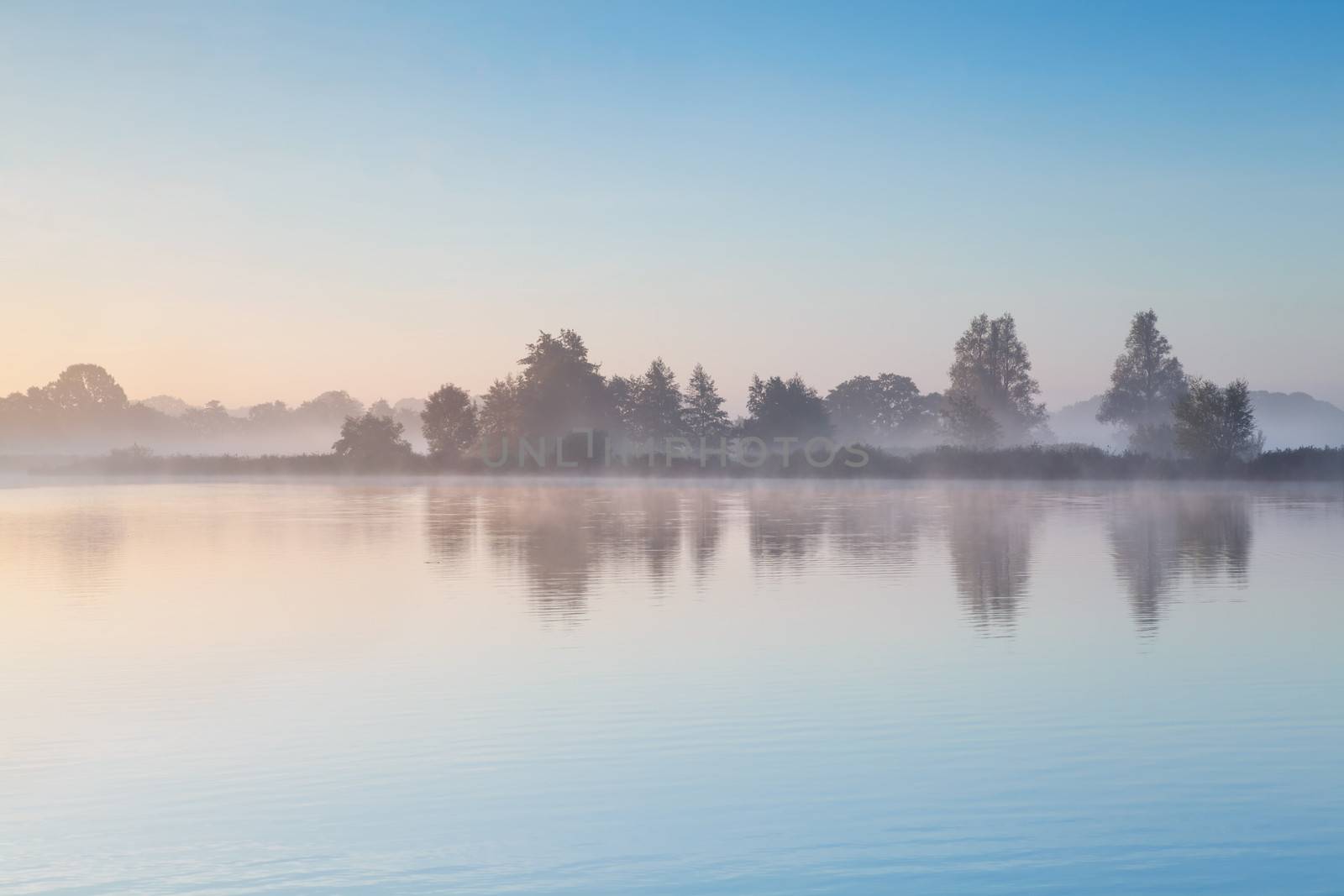 blue sky and morning fog over wild lake