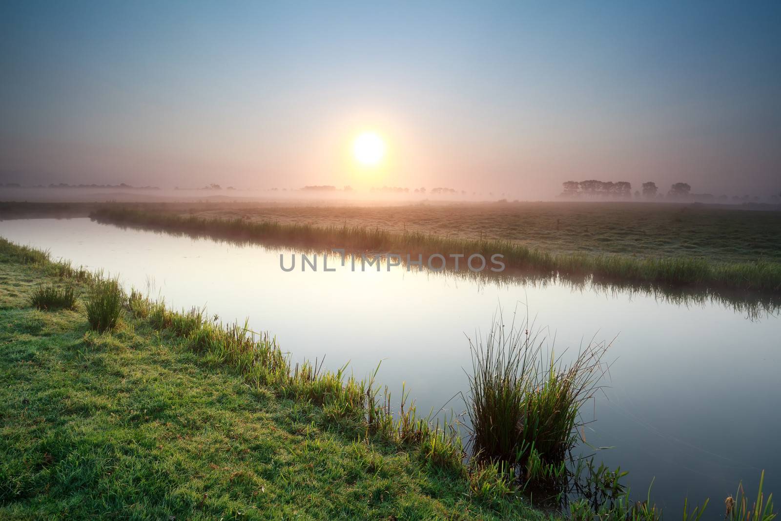 misty sunrise over river on Dutch farmland, Holland