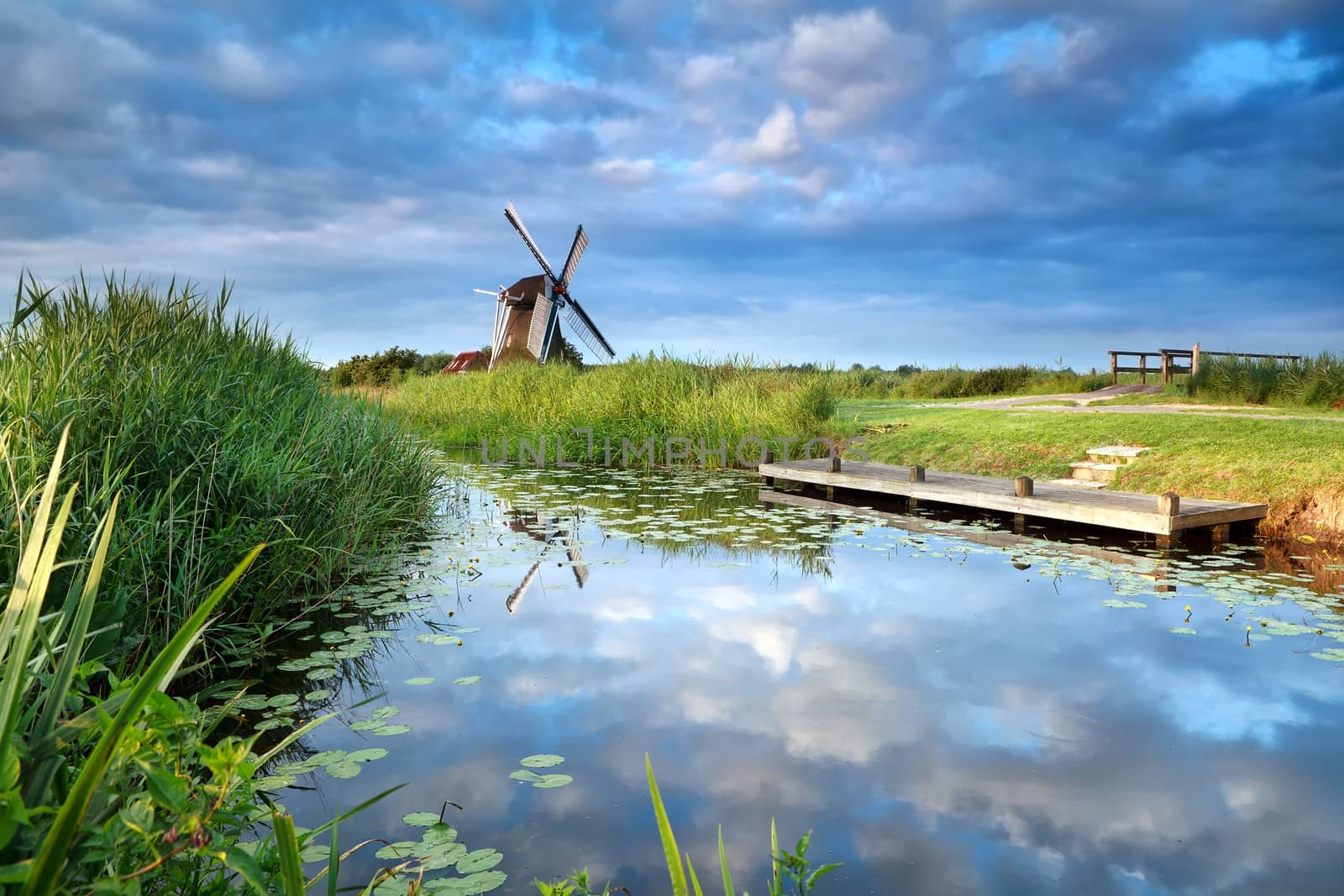 blue sky and windmill reflected in river by catolla