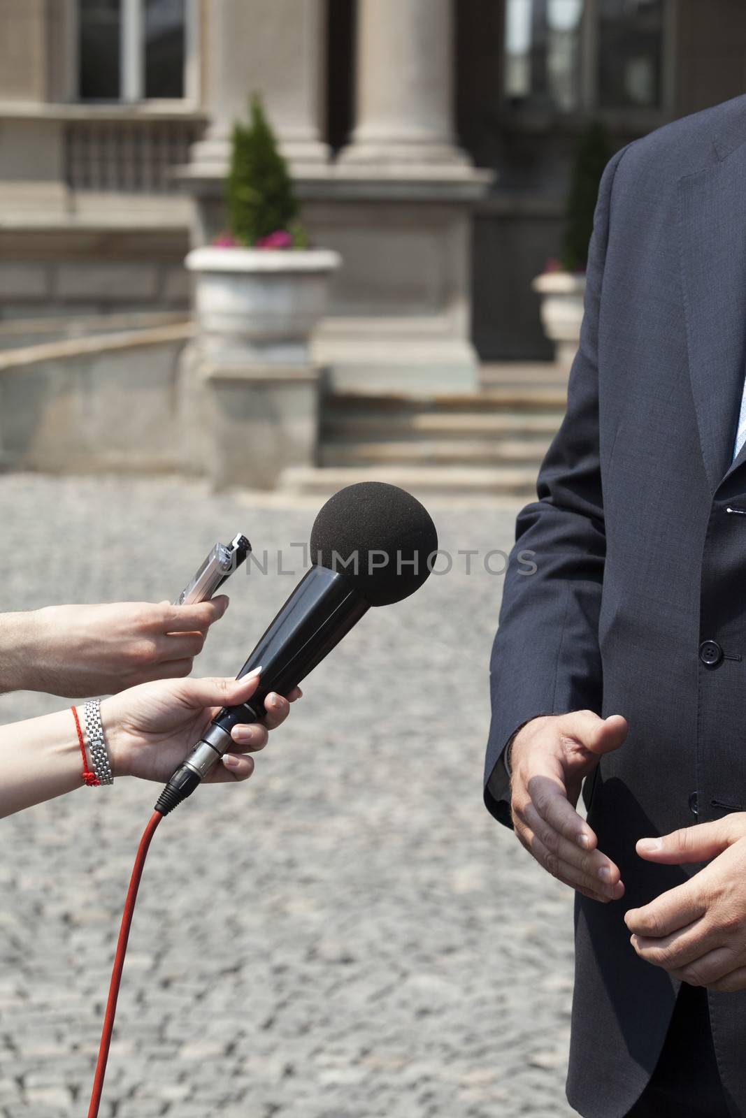 Interview with media microphone held in front of businessman, spokesman or politician