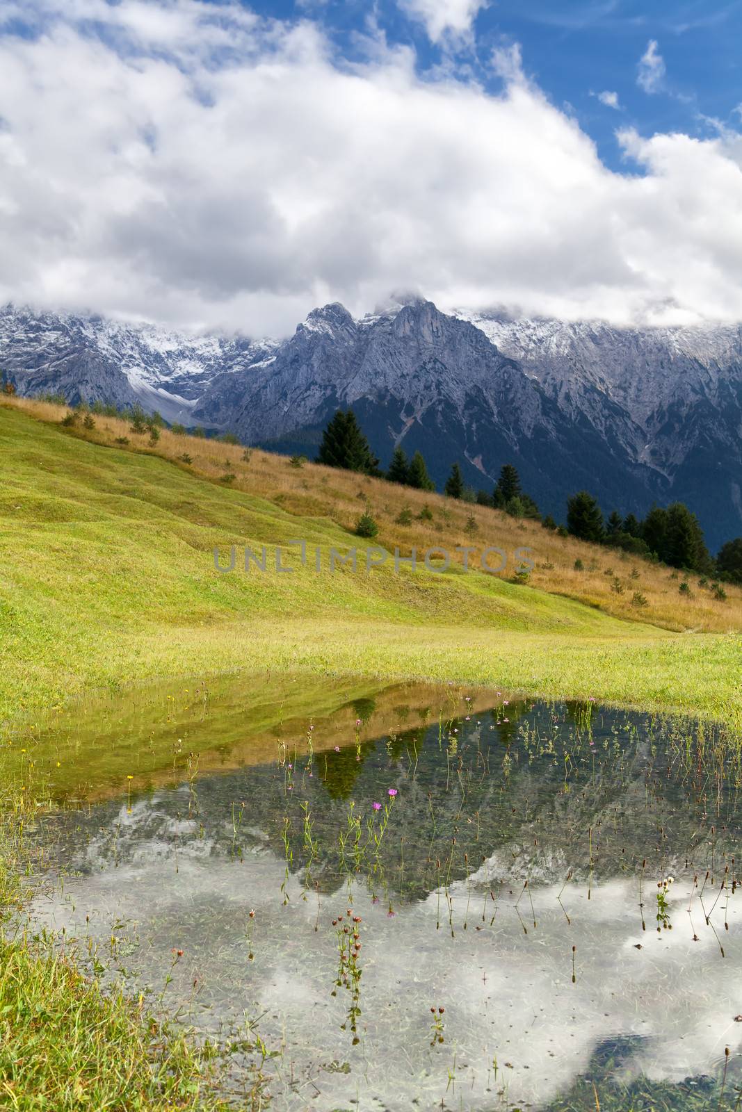 mountains in clouds reflected in lake by catolla