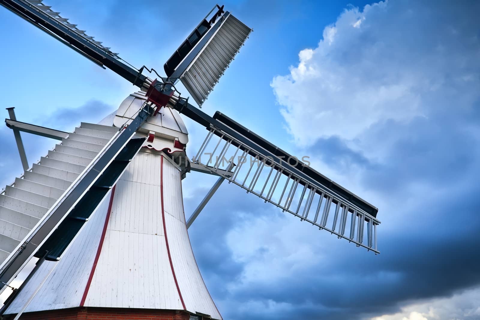 white Dutch windmill over blue sky by catolla