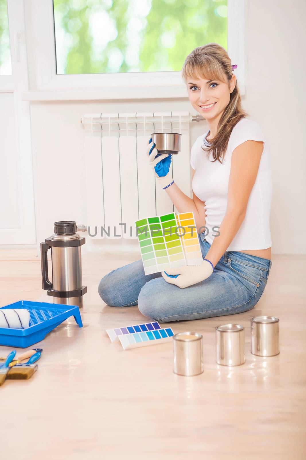 beautiful female painter drinking coffee in new house