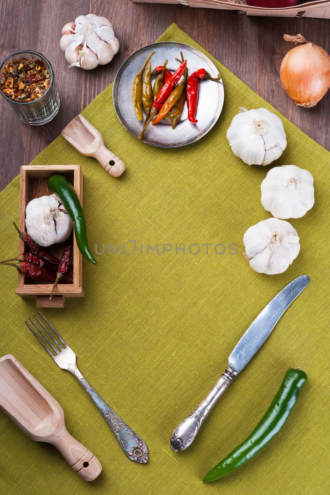 Several kinds of pepper and garlic, on green linen napkin