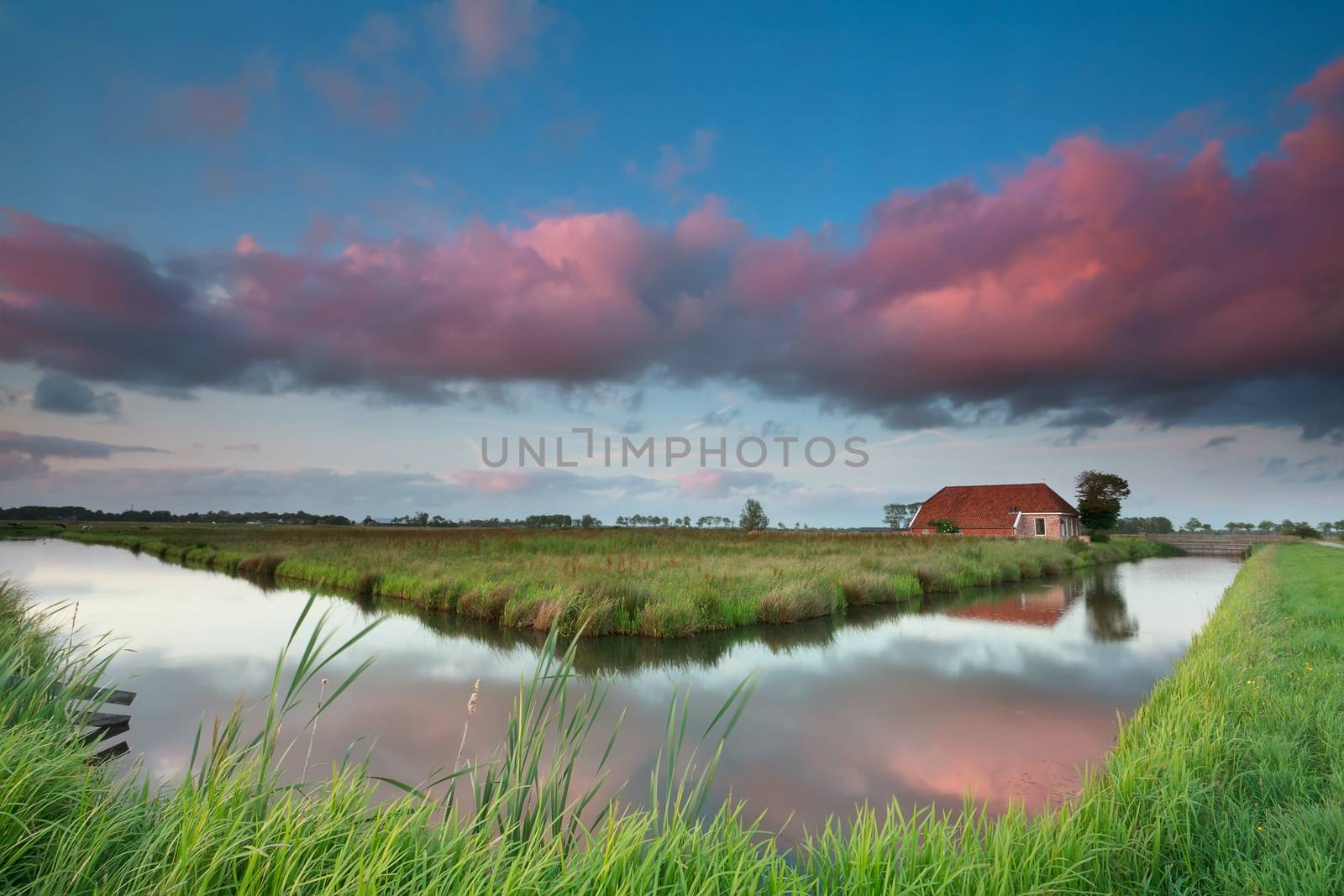 sunset over charming Dutch house by river, Groningen, Netherlands