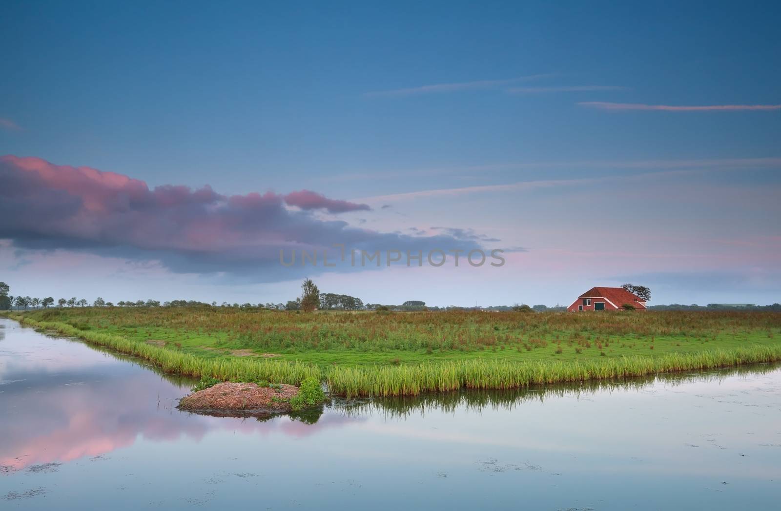 Dutch farmhouse by river at sunset, Groningen, Netherlands