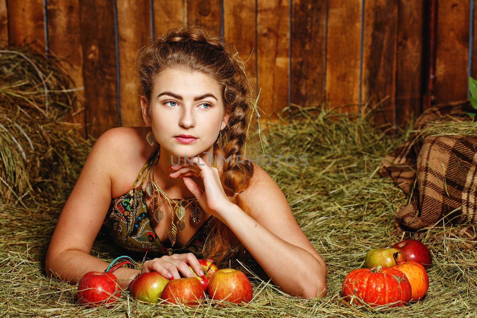 Attractive young rural girl in the hayloft after harvest festival