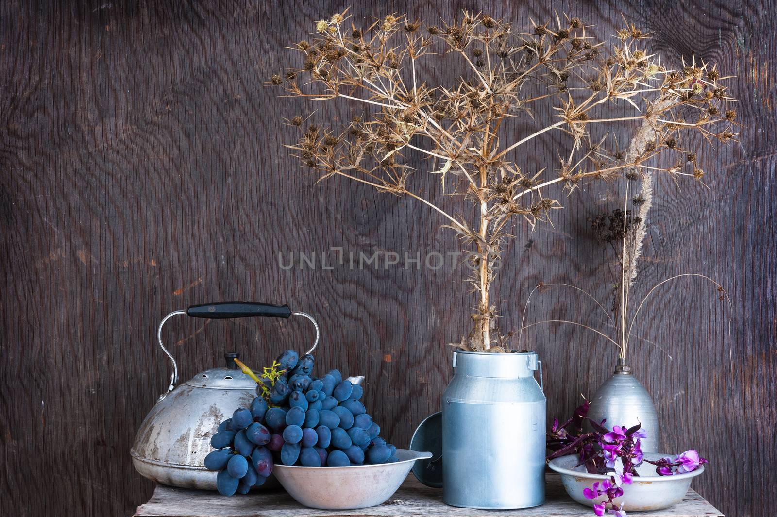 Kitchen utensils on the wooden background with dry autumn prairie flowers