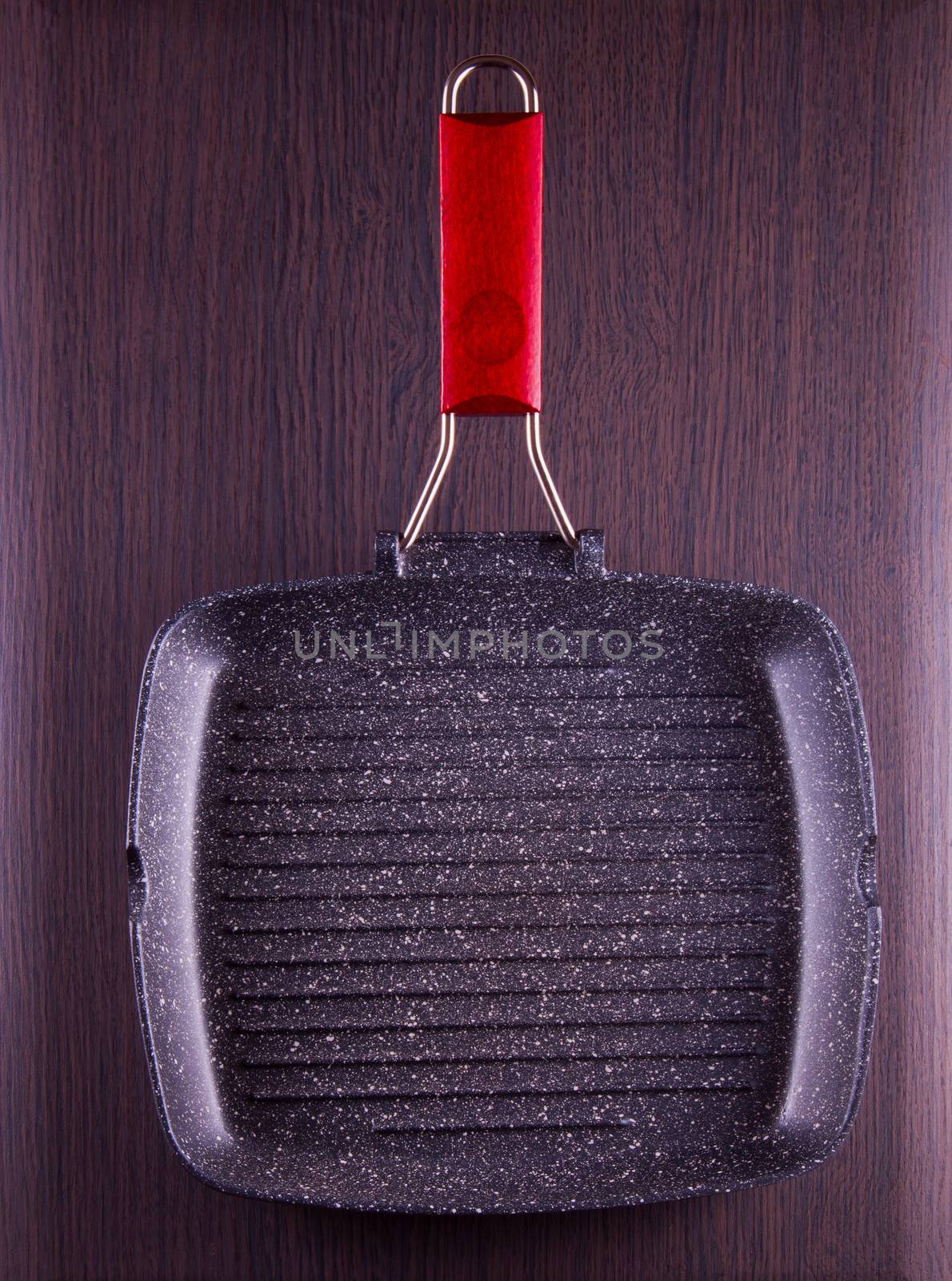 An empty stone pan, over wooden table