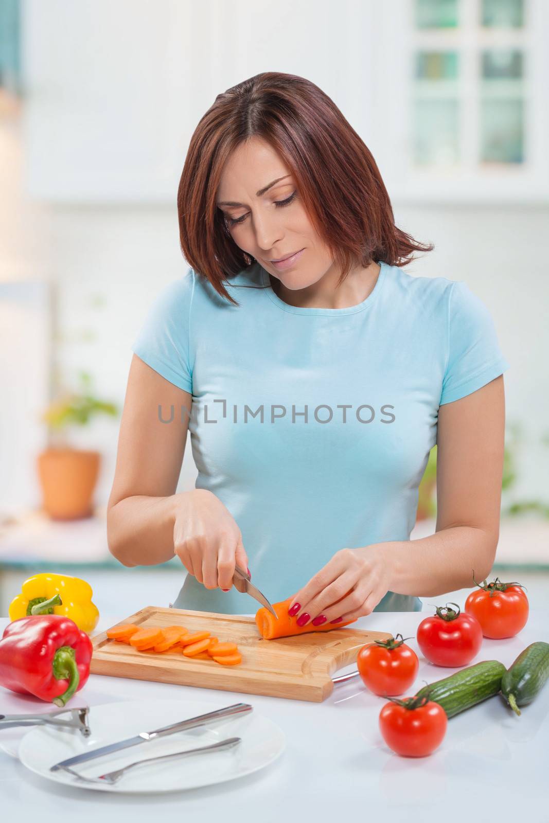 female cutting carrot with kitchen knife at table