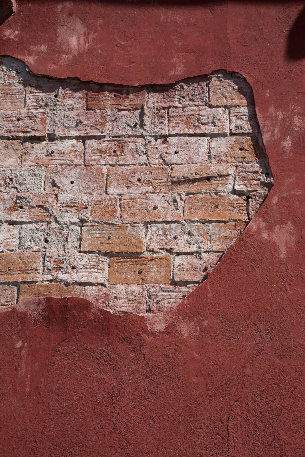Old brick wall with ragged plaster 