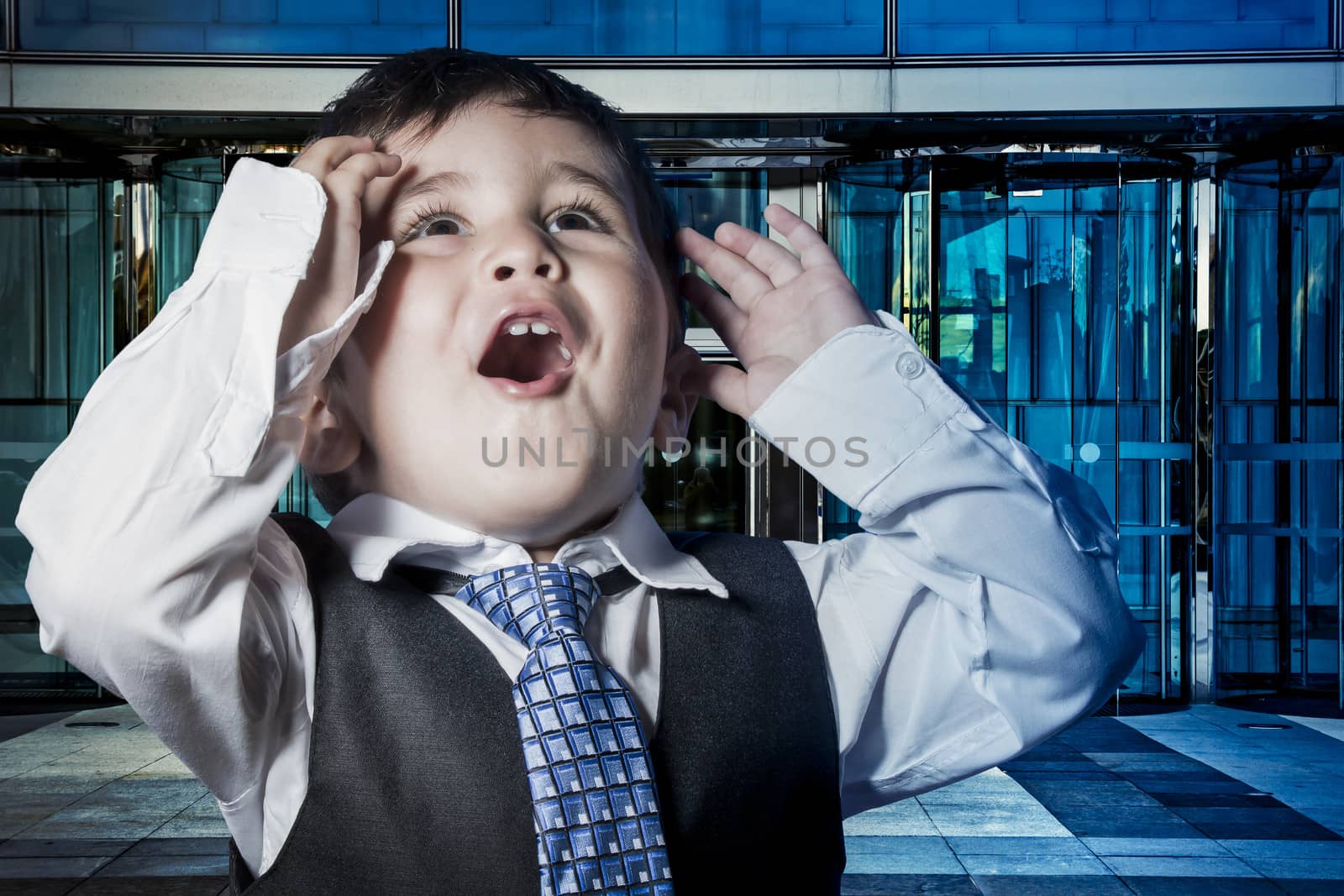 Business, child dressed businessman with hands in his tie and skyscrapers in the background