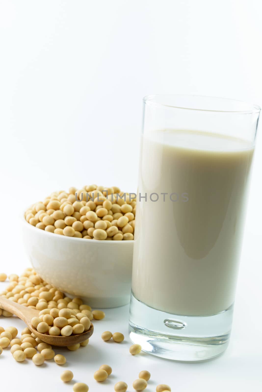 Soymilk and soy beans over white background