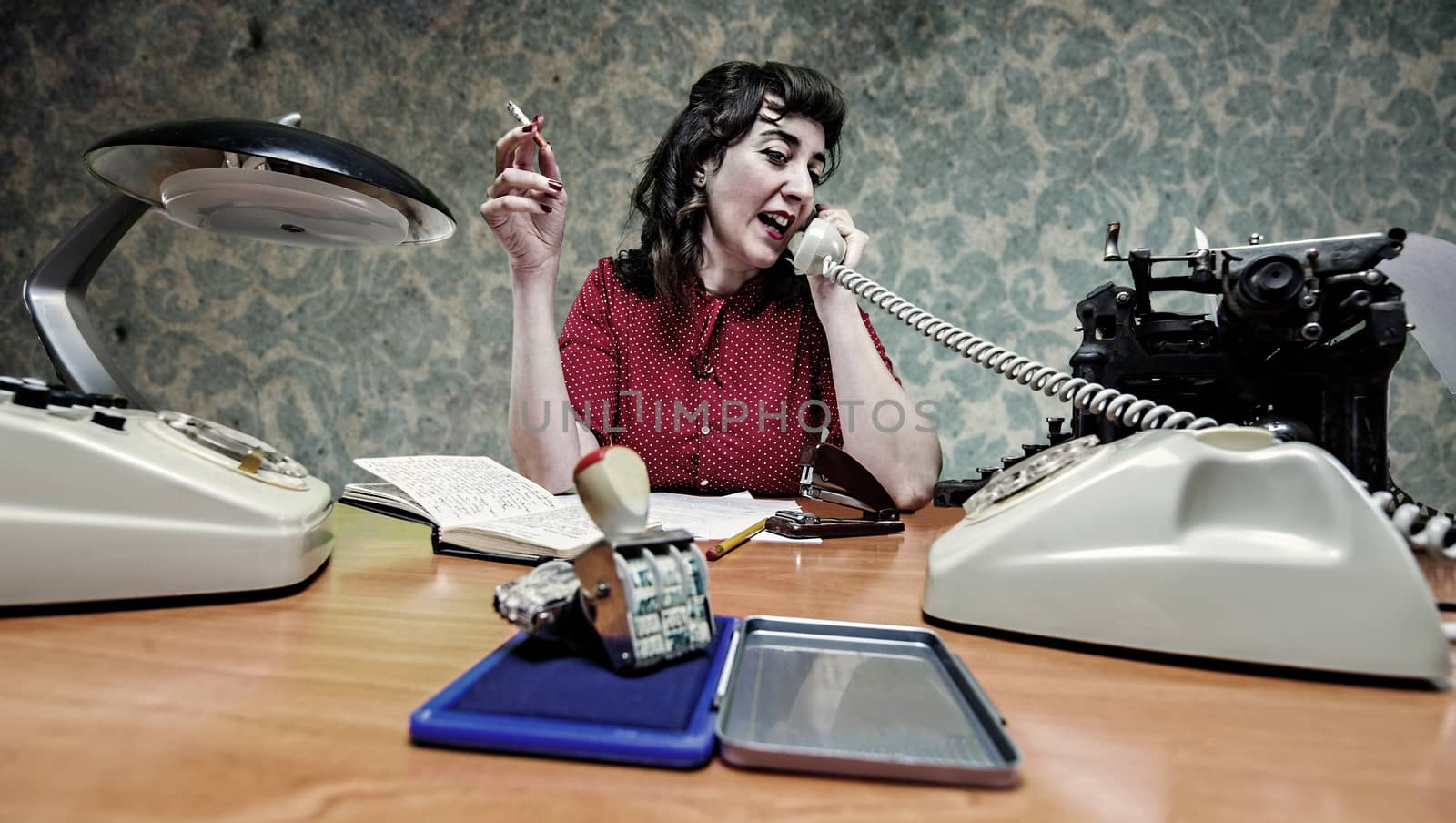 young Secretary smoking a cigarette while talking on the phone, 1960's scene by digicomphoto