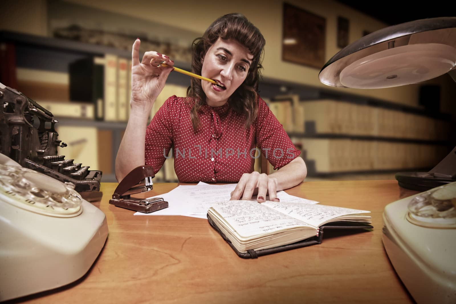 thoughtful clerk with a pencil in your mouth look at your agenda by digicomphoto