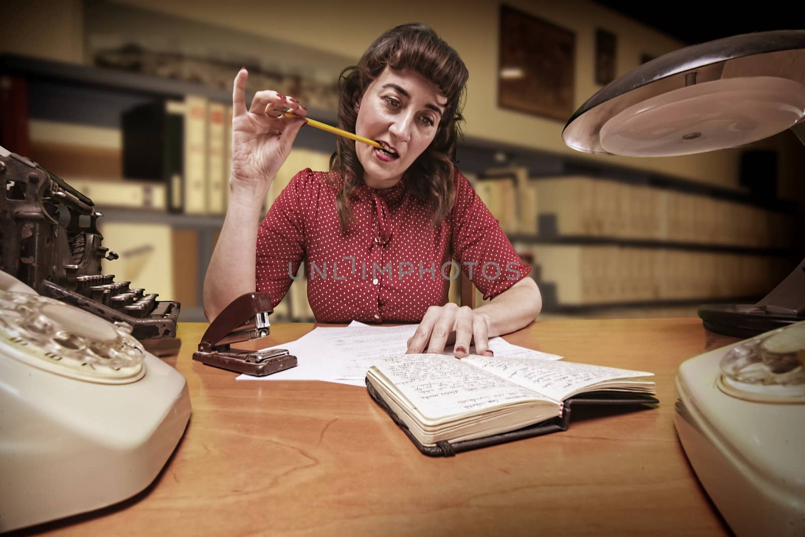 thoughtful clerk with a pencil in your mouth look at your agenda in office, 1960's