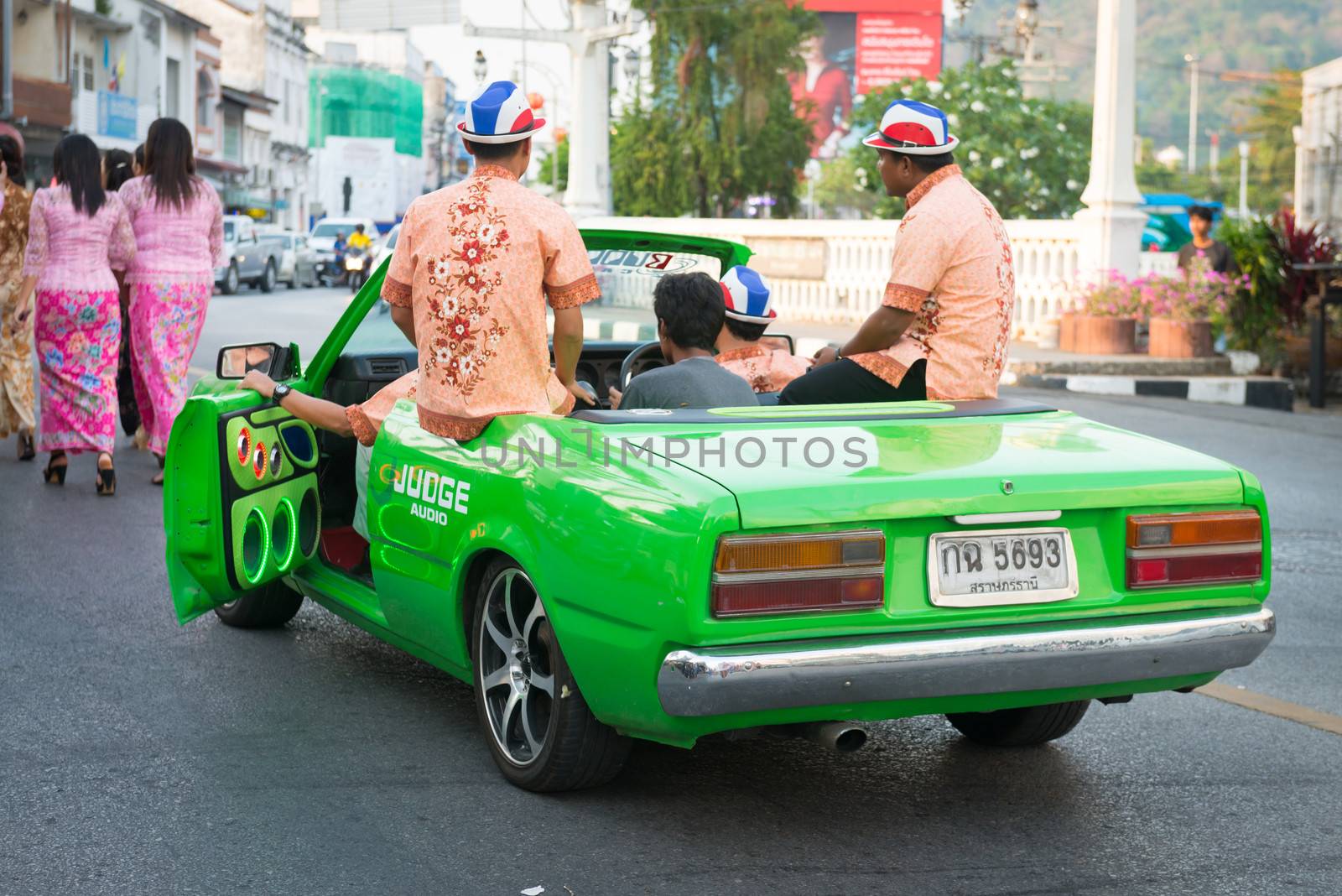 PHUKET, THAILAND - 07 FEB 2014: Phuket town residents on green car take part in procession of annual old Phuket town festival. 
