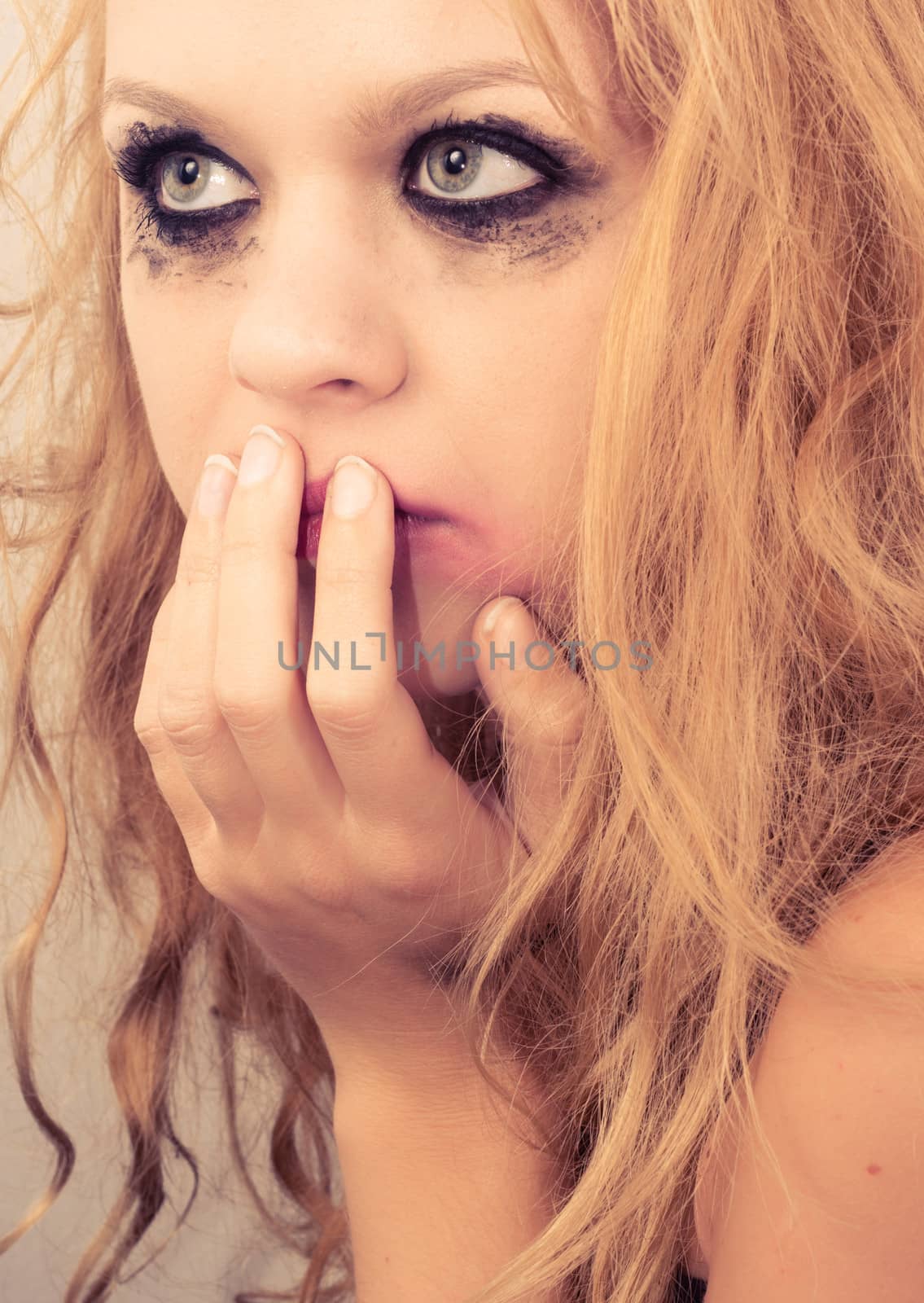 Sad blond girl with terrified expression closeup photo
