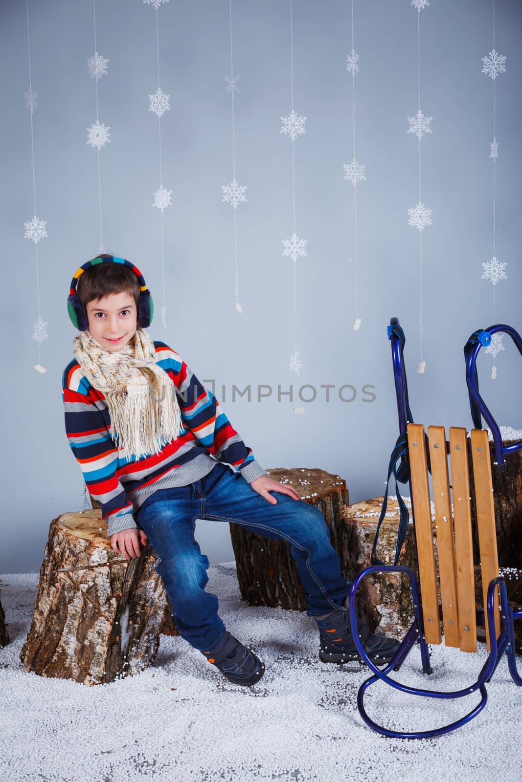 Winter Fashion. Adorable happy fashion boy in winter hat gloves and sweater in studio.