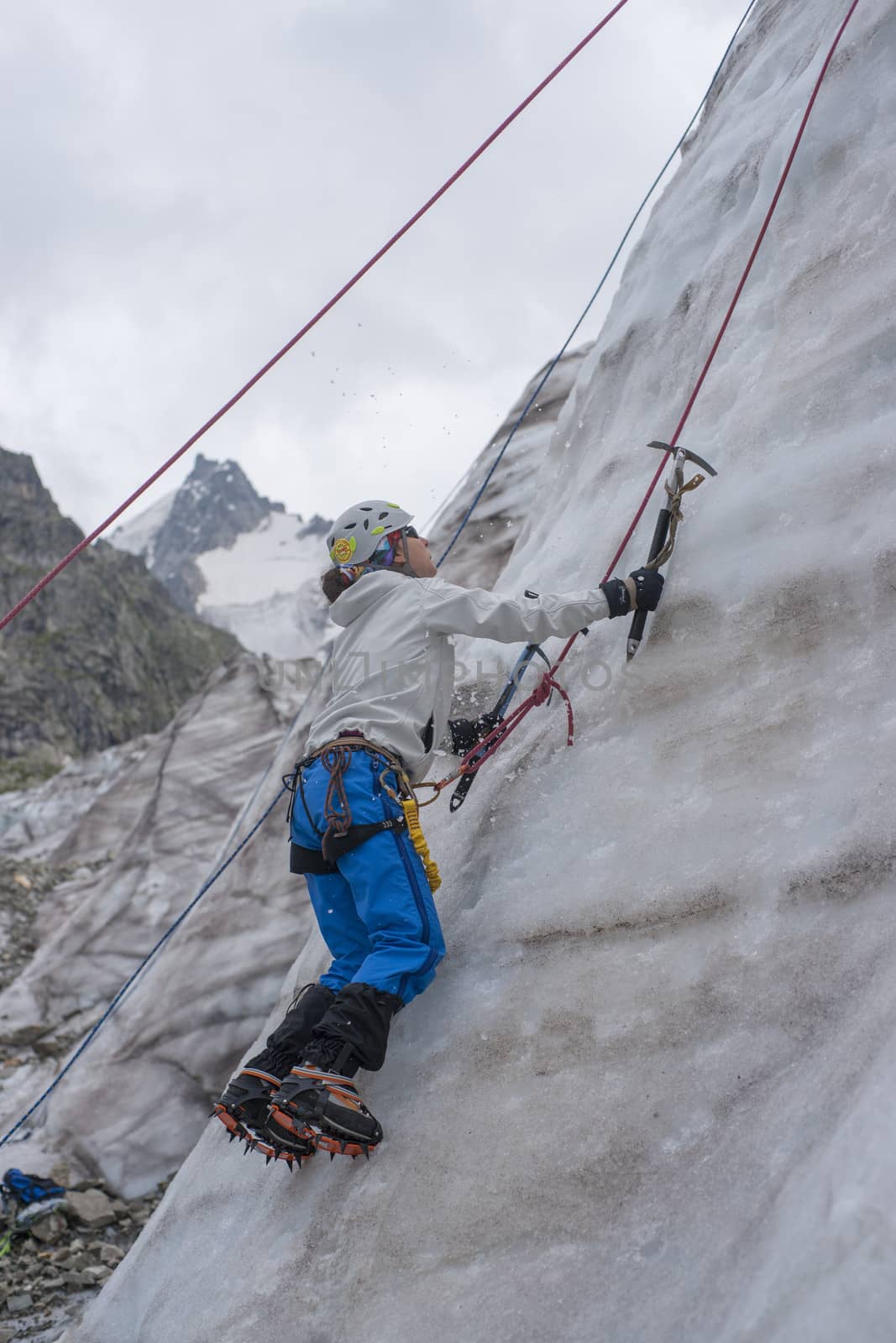 Girl climb up on the ice at glacier