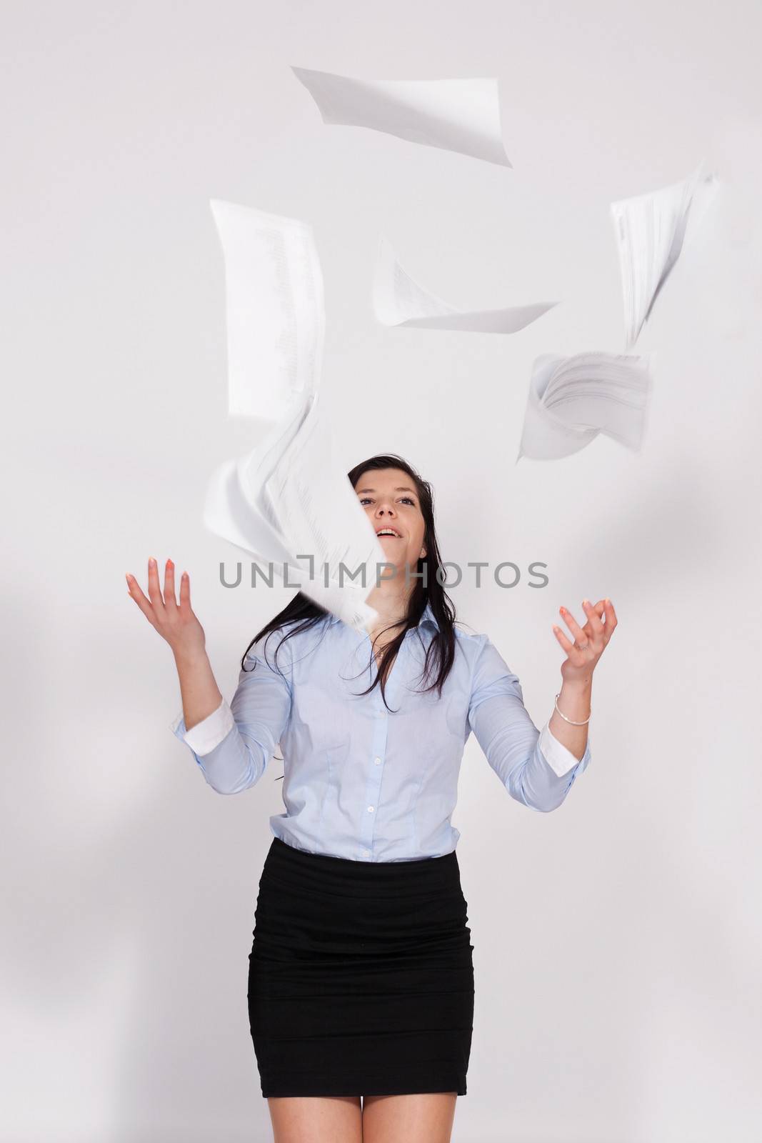 Young woman standing and throws out the paper in the air