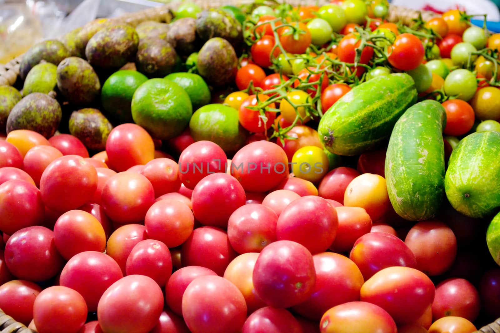 tomatoes and vegetables in a basket by apichart