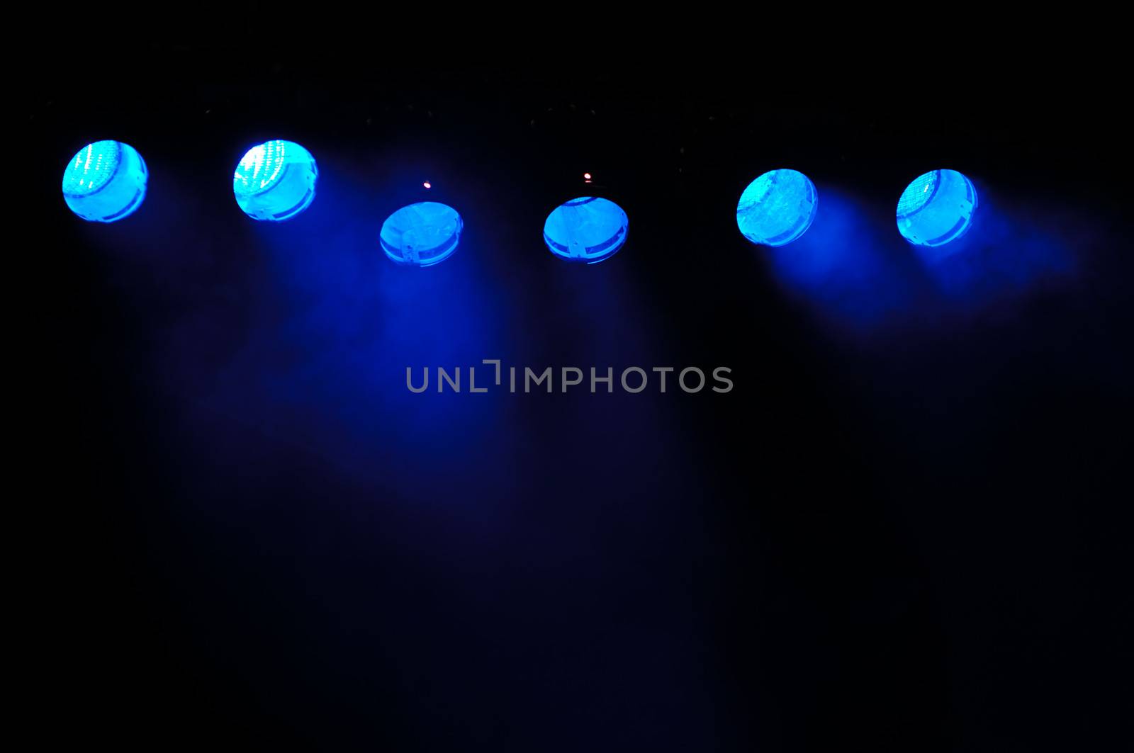 Lights and smoke. Row of blue lights from a stage.