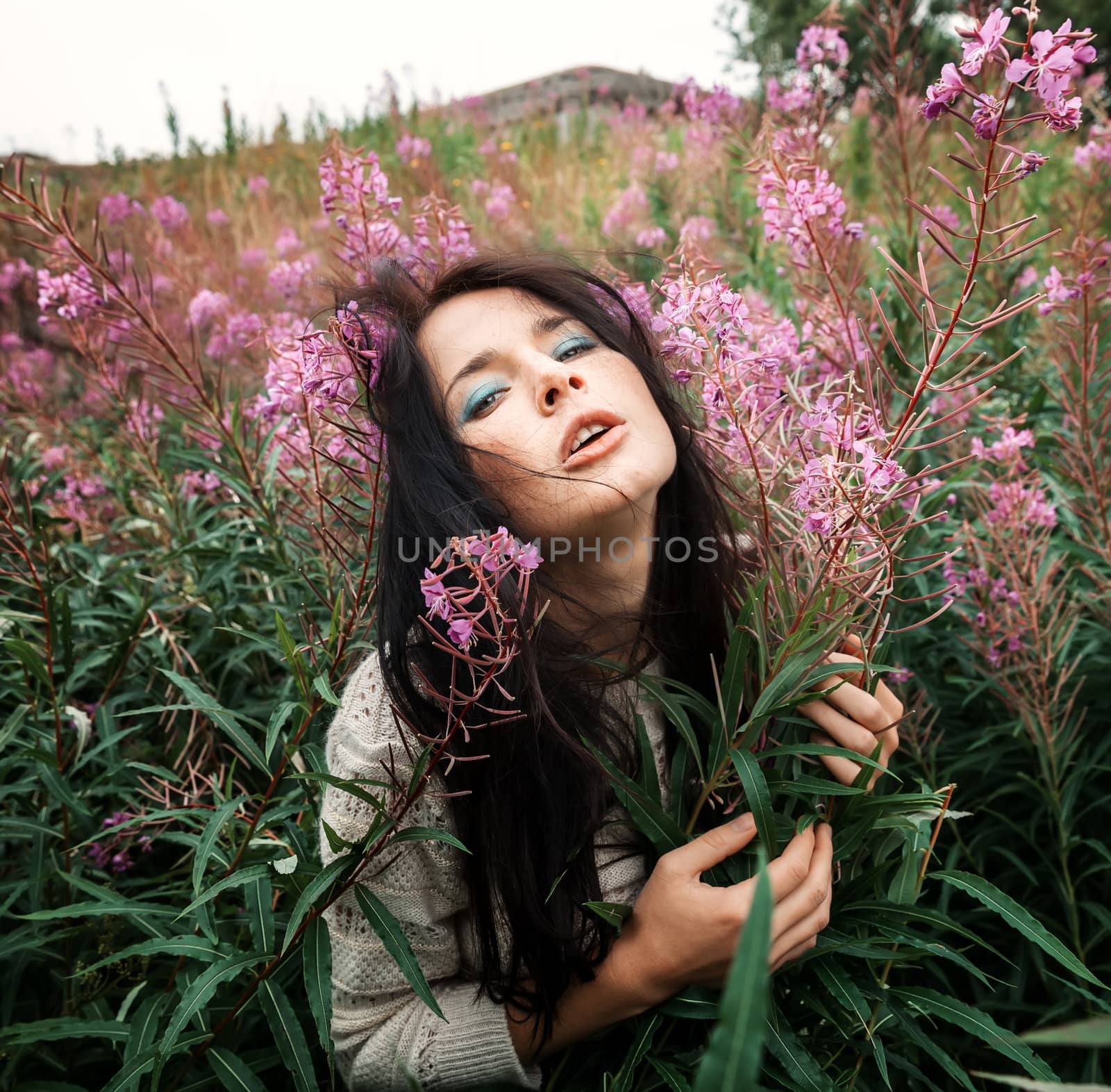 Portrait of beautiful freckled girl among the flowers.