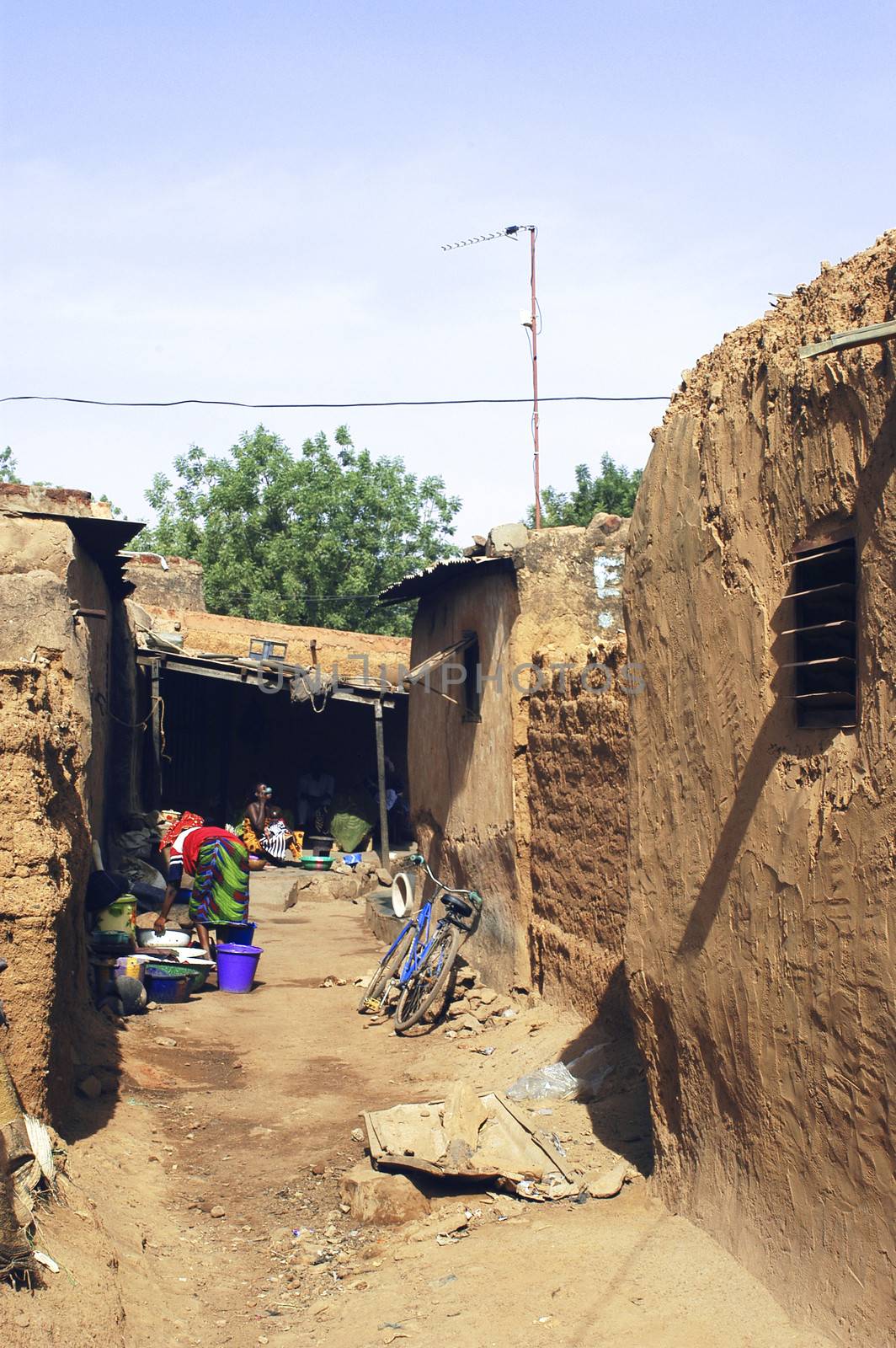 an old lane Bobo-Dioulasso where women are busy with household activities