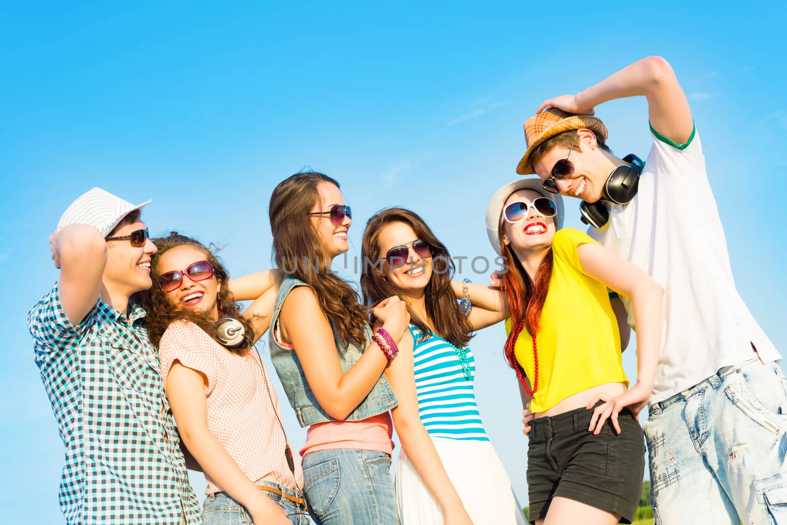 group of young people wearing sunglasses and hats hugging and standing in a row, spending time with friends