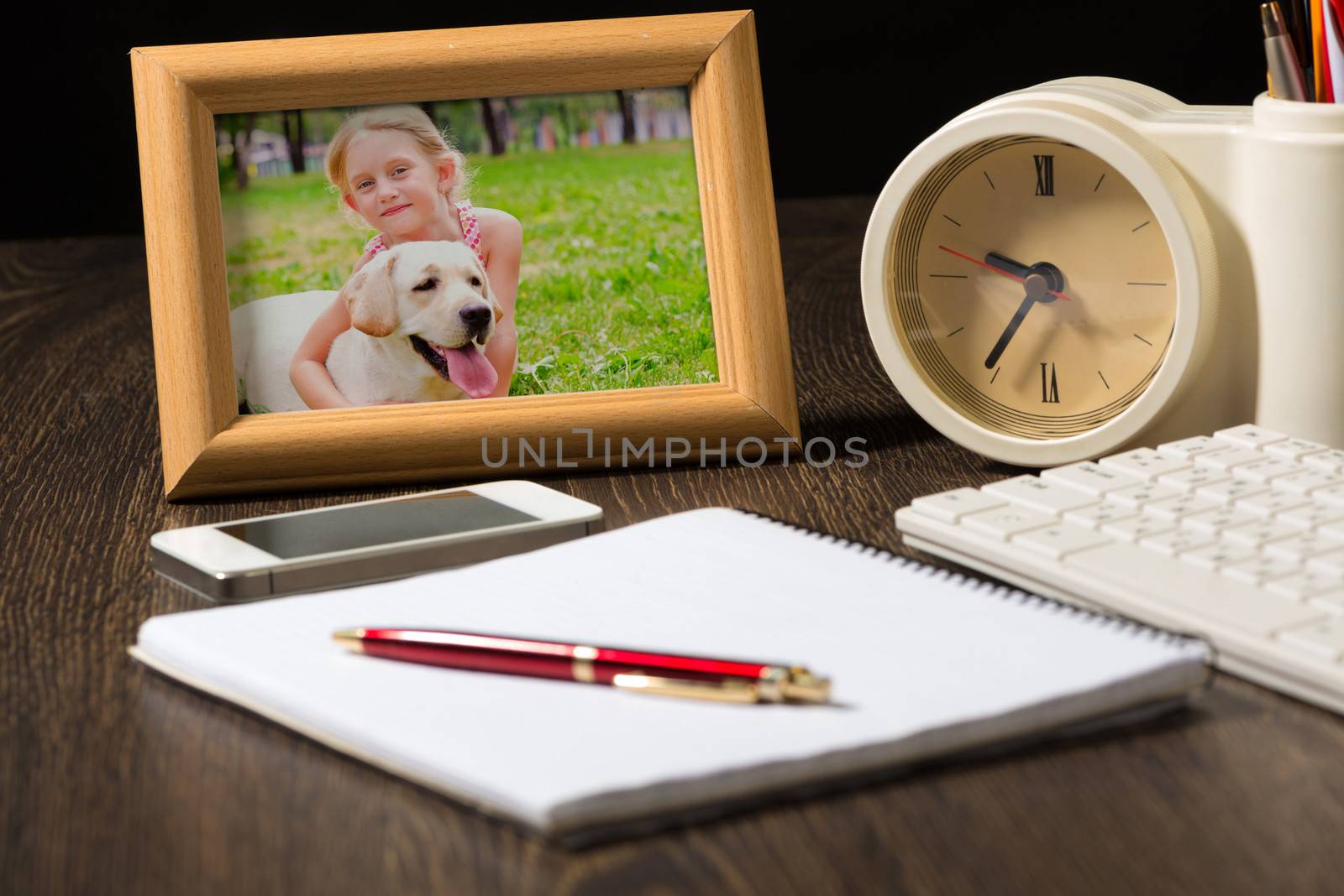 photo frame, mobile phone and notebook with a ballpoint pen. Workplace of the businessman.