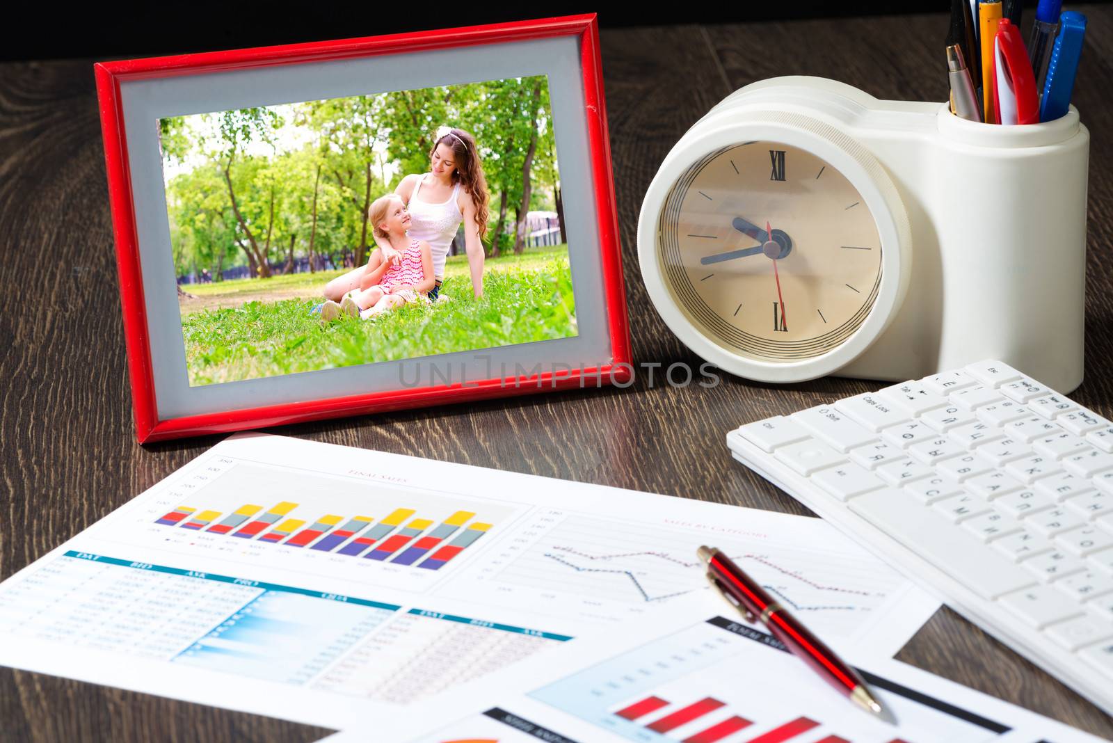 photo frame, business paper with growth graph, table clocks and keyboard. Workplace of the businessman.