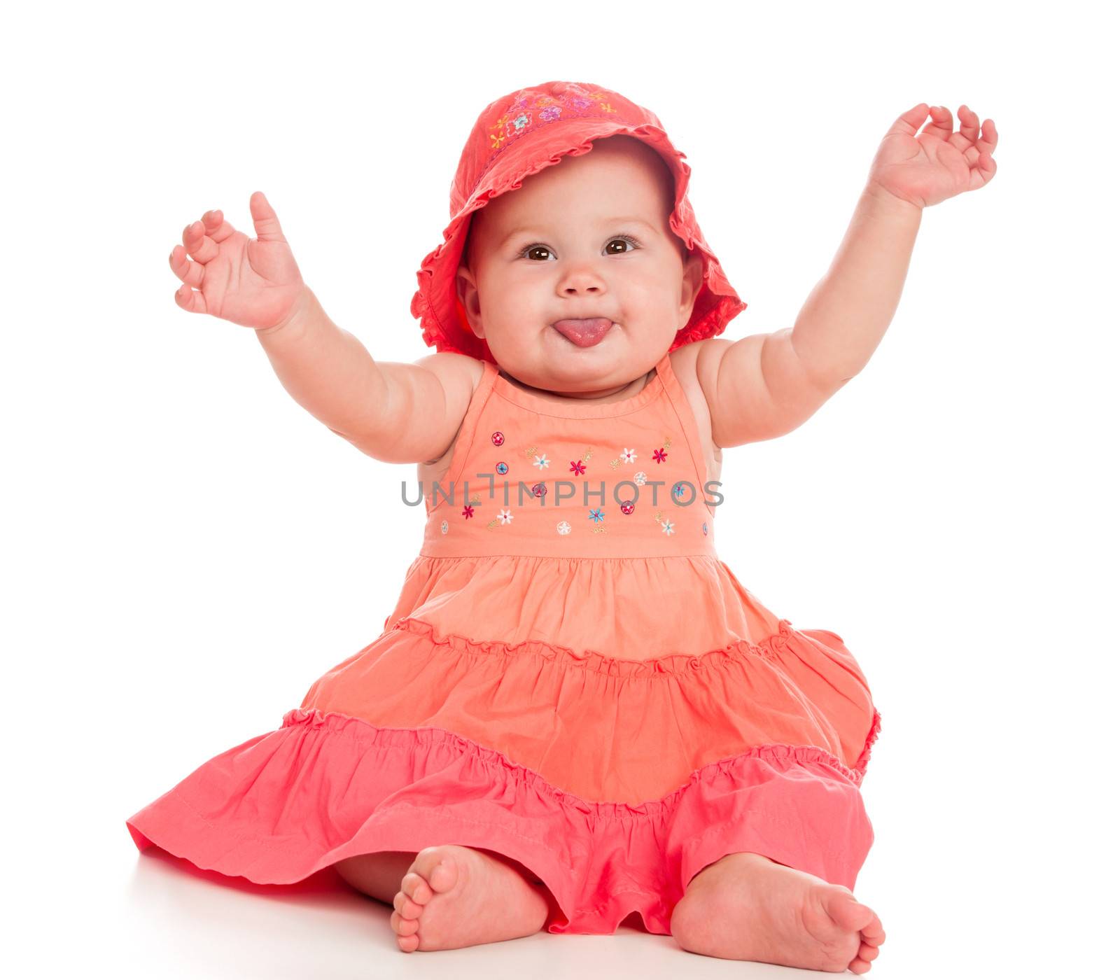 Beautiful baby girl sitting in a pink dress and hat. Isolated on white