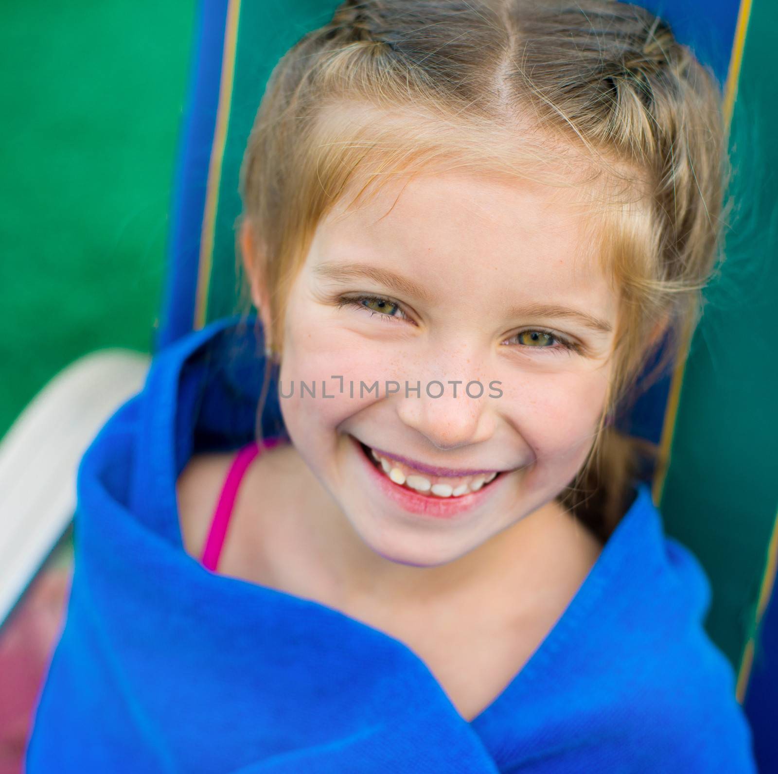 little cute girl wrapped herself with a blanket near the swimming pool