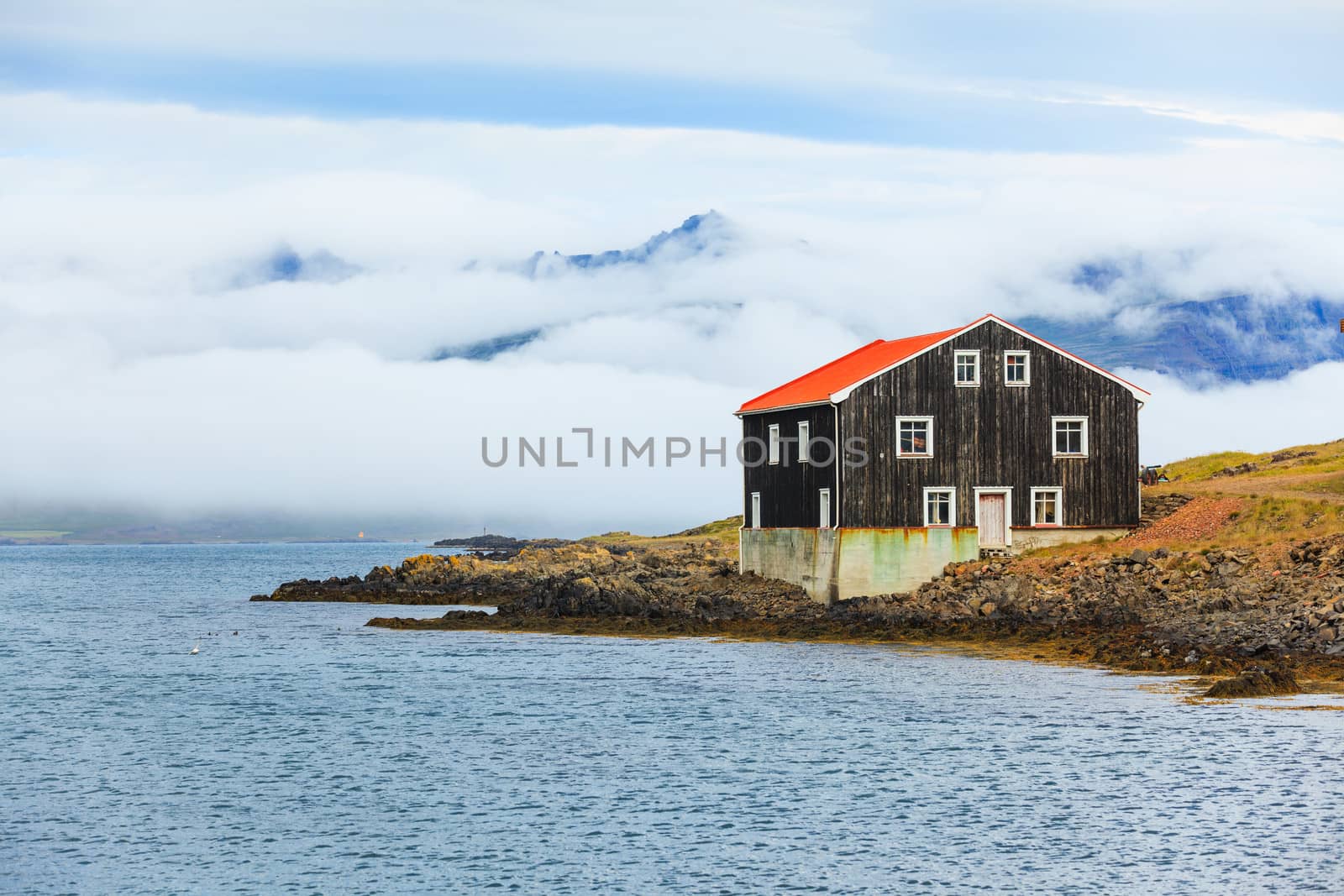 Lonely Black Wooden House at coastline in East Iceland.