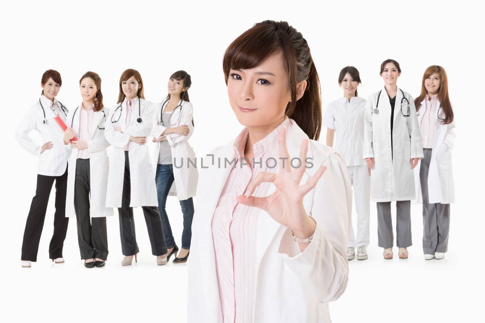 Asian doctor woman stand in front of her team and give you an ok sign, closeup portrait on white background.