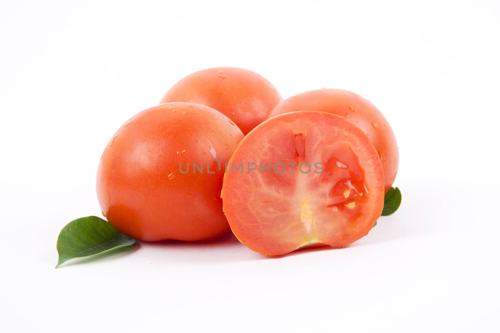 Fresh tomatos, vegetables pile on a white background.