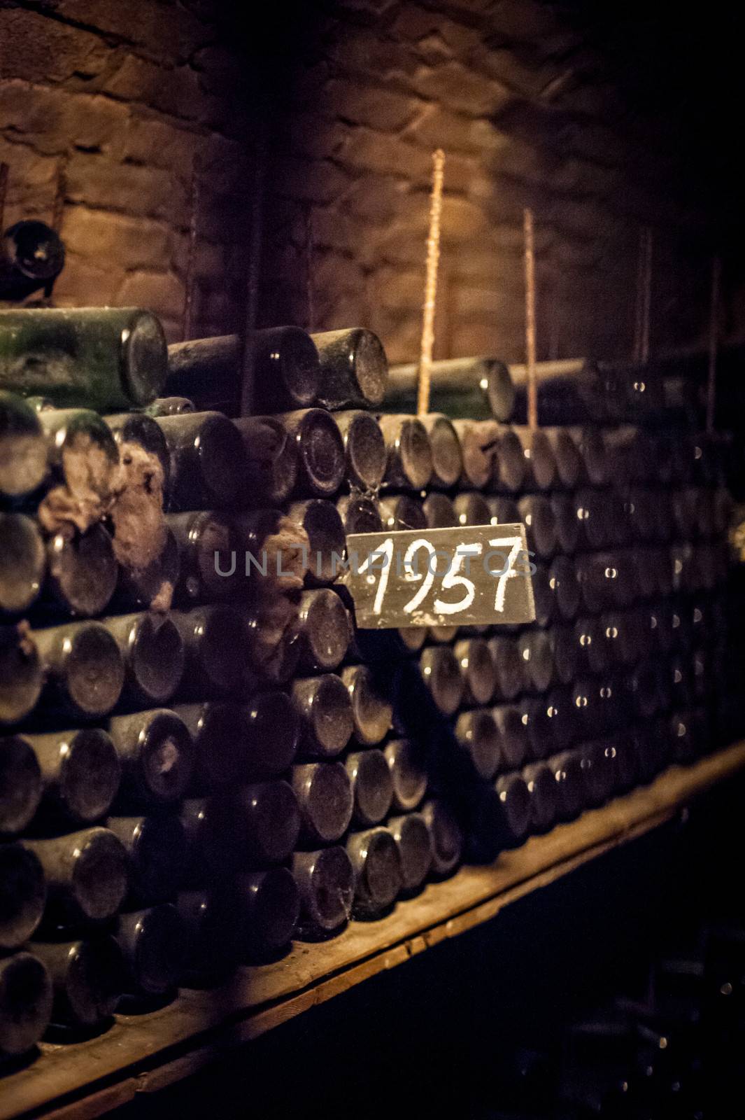 some very old and dusty wine bottles in a wine cellar