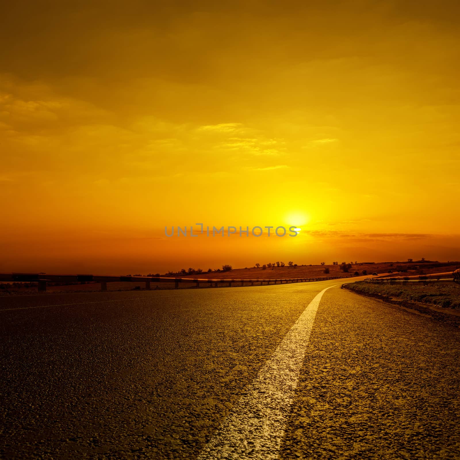 asphalt road to orange horizon in sunset by mycola