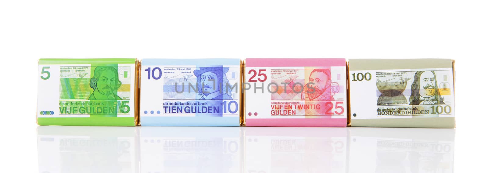 Chocolate money bars with old Dutch money over white background