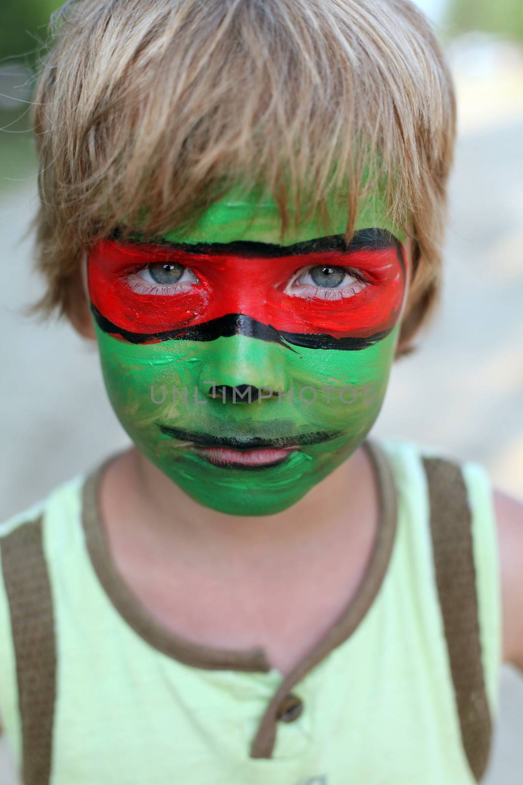 boy child with a painted mask on her face