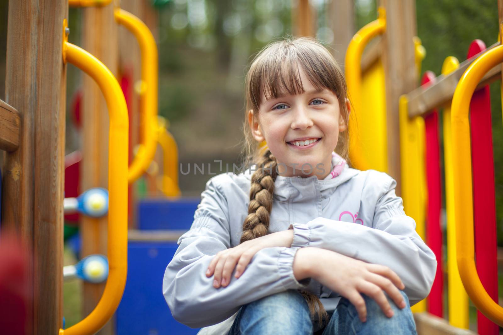 Cute little girl on the playground in spring day