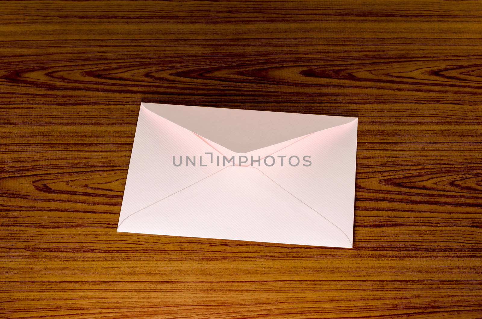 soft pink envelope on wooden background