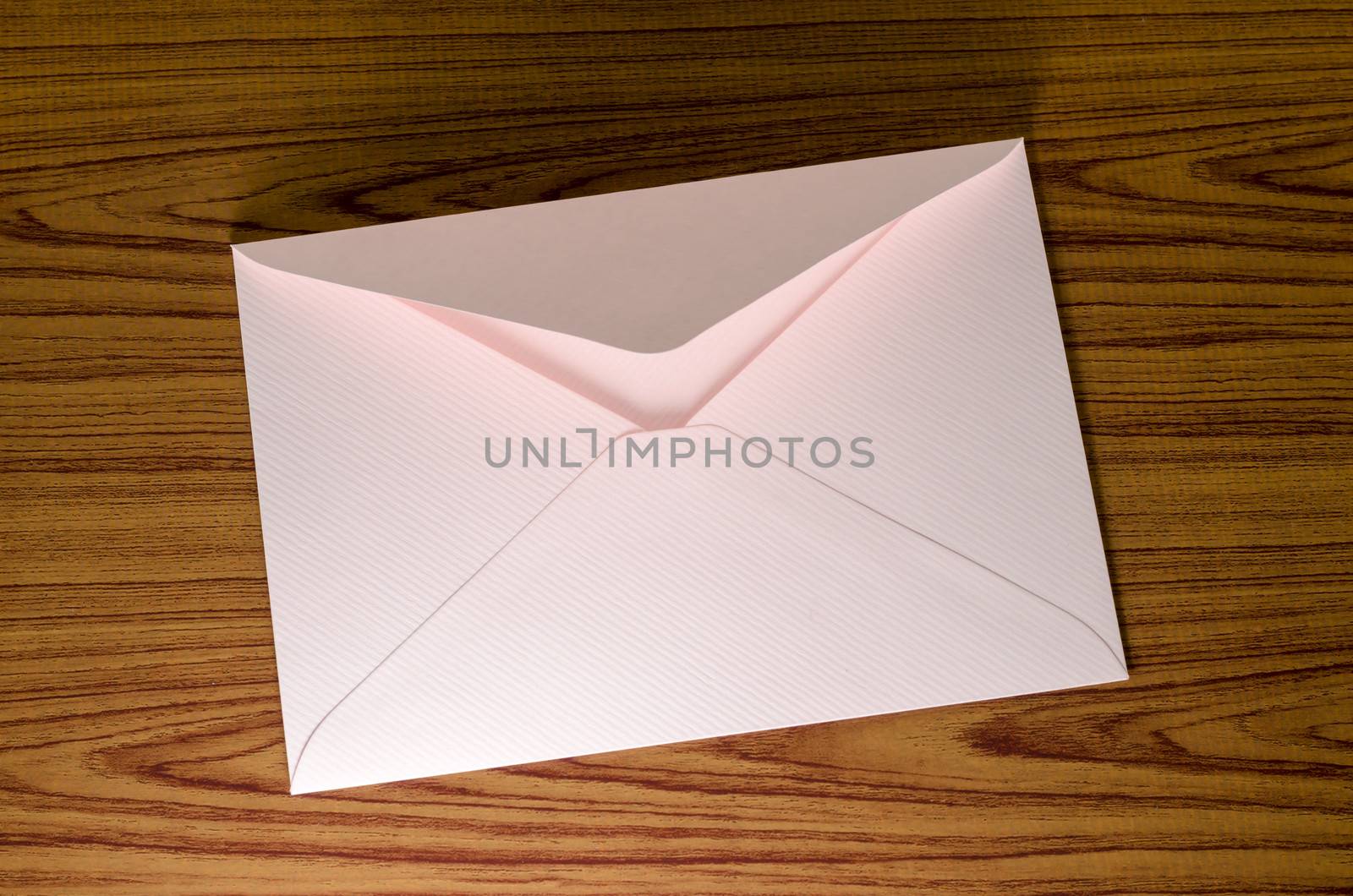 soft pink envelope on wooden background